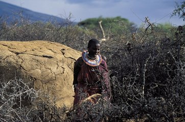Masai woman in font of her manyata in savanna Tanzania