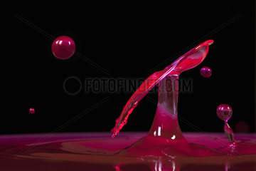 Drops of water colored in red on black background