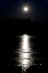 Full moon reflecting off a icy lake Luberon France