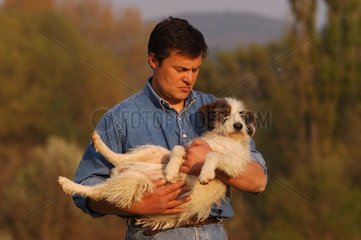 Homme portant son chien dans ses bras