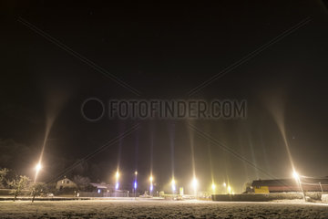 Light pillars in winter  Thyez  Alps  France. In an icy atmosphere (-7 Â° C)  artificial light in the town of Thyez is reflected in ice crystals suspended in the air. This phenomenon known as light pillars is common in the far north but rare in our latitudes.