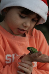 Girl carrying a tree frog on hand