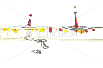 Drops of colored water and air bubbles on white background