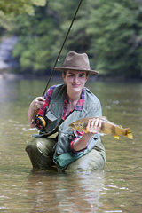 Young woman presenting a wild Trout of the Doubs (Salmo trutta fario)  Fly fishermen on the French-Swiss Doubs river  La Goule  Franche-Comte  France