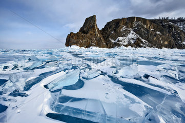 Chaos of ice on the surface of Lake Baikal and Shaman rock  Olkhon island  Siberia  Russia