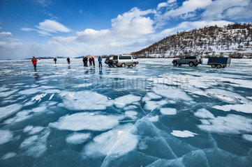 Cars and peoples on ice on the surface of Lake Baikal  Siberia  Russia