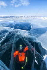 Diver seen through the ice of Lake Baikal  Siberia  Russia