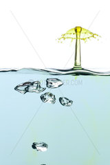 Drops of colored water and air bubbles on white background