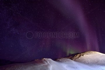 Hill behind the village of Ittoqqortoormiit under aurora borealis  Greenland  February 2016