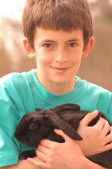 Enfant portant un lapin bélier noir