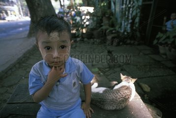 Katze schlÃ¤ft in der NÃ¤he eines Jungen mit bemaltem Gesicht Burma