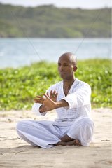 Man praticing yoga on a beach in Martinique Island