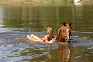 Woman swimming with his horse - France