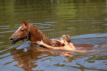 Woman swimming with his horse - France