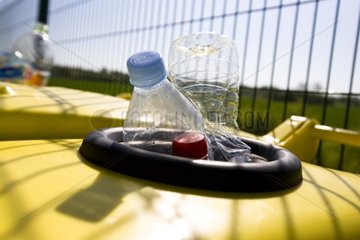 Plastikflaschen  die über einen gelben Behälter hinausgehen