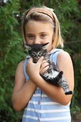 Girl cuddling a kitten - France