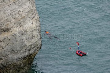 Diver on the surface at the foot of cliffs at Etretat  Normandy  France