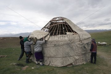 Nomadic family reassembling a yurt in Kyrgyzstan