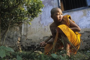 Young novice cleaning the monastery of Luang Prabang Laos