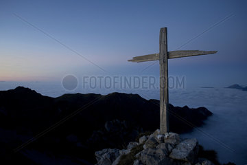 Wooden cross above a sea of ??fog  Alps  France