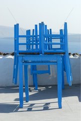 Blaue StÃ¼hle  die auf einer Tischinsel Santorin gestapelt sind