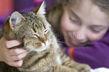Ten year old girl hugging her cat