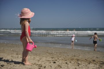 Girl with pink hat and watering seaside France