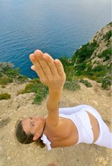 Woman practicing yoga in front of the Mediterranean Sea