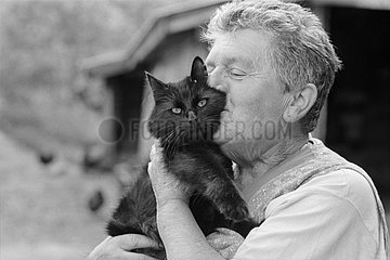 Woman kissing with tenderness a black cat