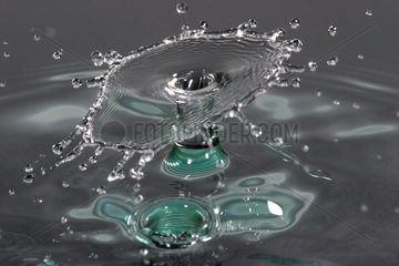 Single drop of water falling in water