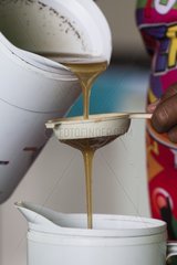 Filtering the honey using a sieve. Training organized by the Chico Mendes Scientific Institute for Ribeirinhos populations living along the Araguari River in the Amazon with the objective of producing honey initially for personal consumption and eventually for sale; Trainer Douglas Schwank.