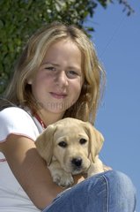 Girl holding her Labrador young person in the arms