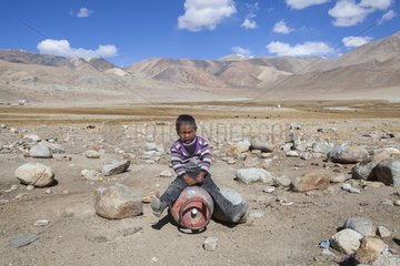 Boy playing riding a gas cylinder  Surroundings of Korzok  Leh  Ladakh  Himalayas  India