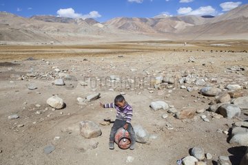 Boy playing riding a gas cylinder  Surroundings of Korzok  Leh  Ladakh  Himalayas  India