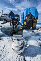 Scuba divers preparing for ice diving  Lake Baikal  Siberia  Russia