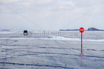 Car on an ice road on the surface of Lake Baikal  Siberia  Russia