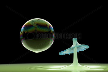 Drop of colored water and soap bubble