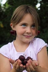 Girl holding cherries in her hands - France