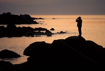 KÃ¼stenstein bei Sonnenuntergang mit Mann auf Felsen Frankreich
