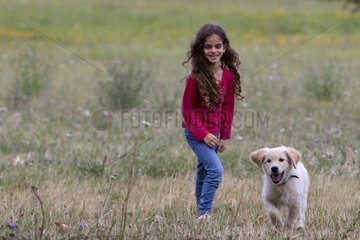 Girl playing with a young Golden Retriever Provence