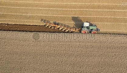 Ploughing of a barley field harvested beside a corn field