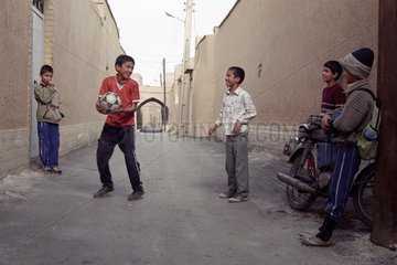Boys iranniens playing football in the street
