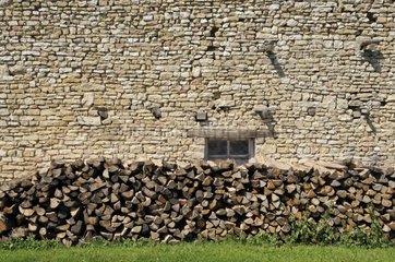 Lager Holz zu einer alten Steinmauer einer Farm