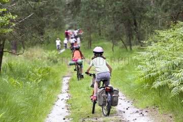 Children with bicycles in a forest path