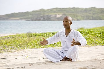 Man praticing yoga on a beach in Martinique Island