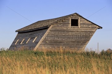 Old barn tilted by the prevailing winds Saskatchewan Canada