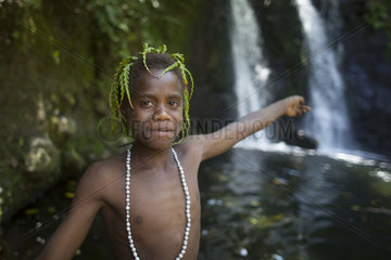 Boy with necklace showing a waterfall - Tanna Vanuatu