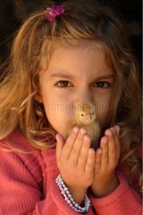 Young girl kissing a chick [AT]