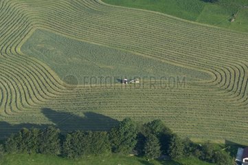 Air sight of a tractor mowing grass of a field Doubs