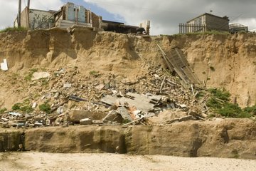 Remains of collapsed houses after severe coastal erosion